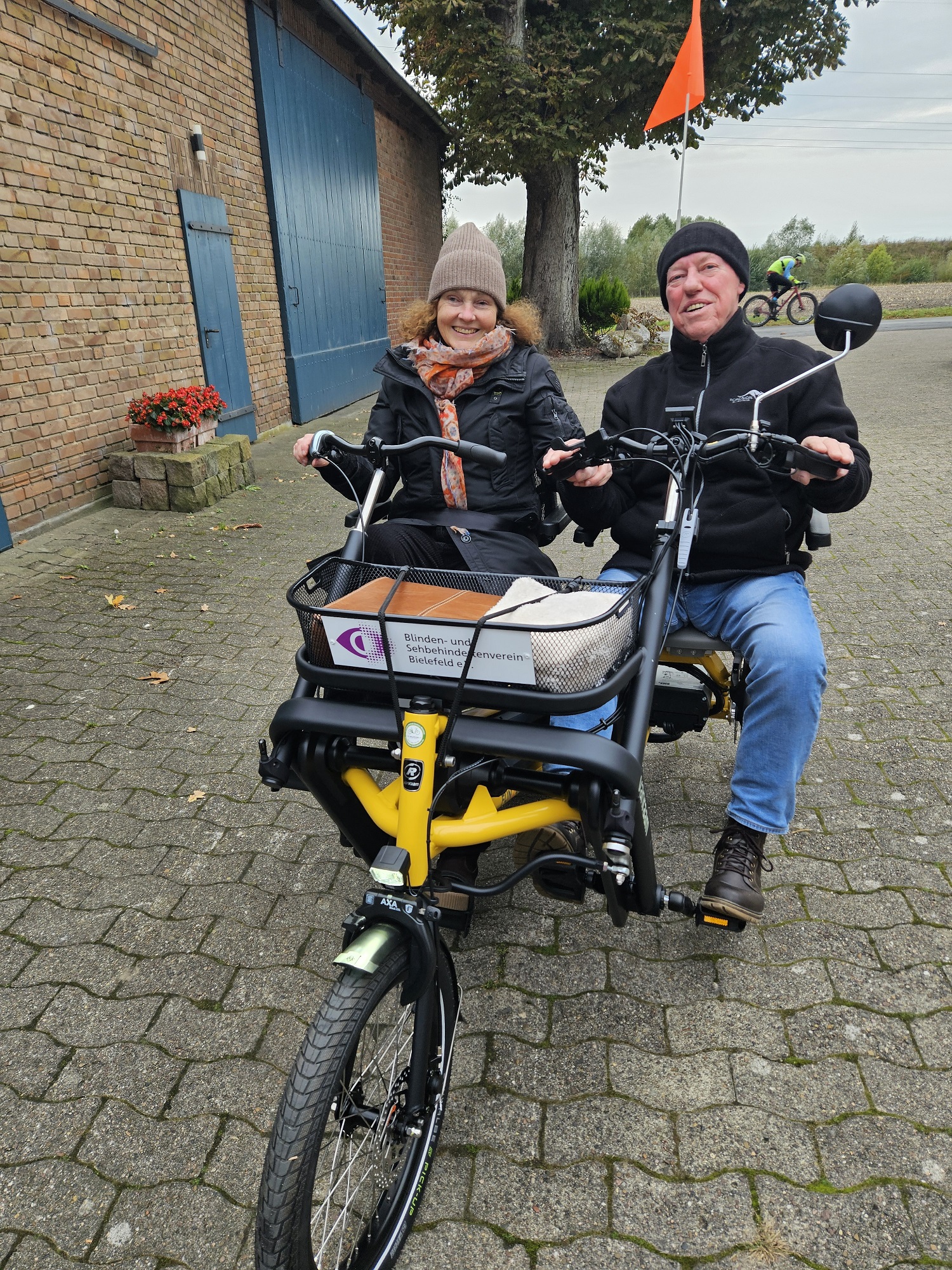 Blinde Frau und Begleiter sitzen auf dem neuen Paraleltandem